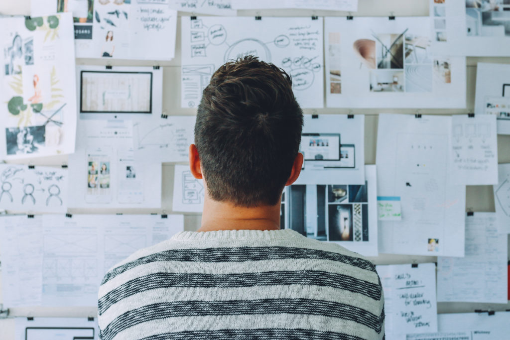 Man using a whiteboard to plot out ideas.