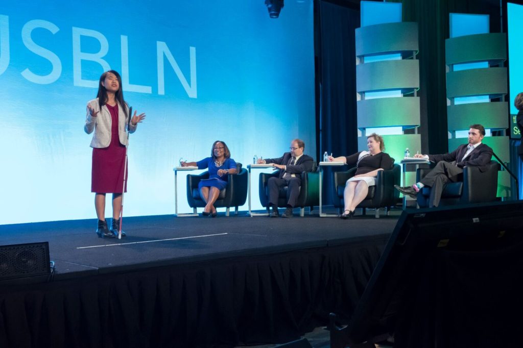 Rising Leader presents a business pitch in front of a panel of experts.